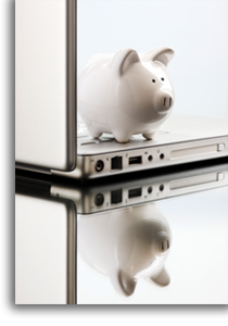 A piggy bank ontop of an open computer.