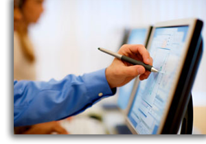 A man writing on computer screen with data.